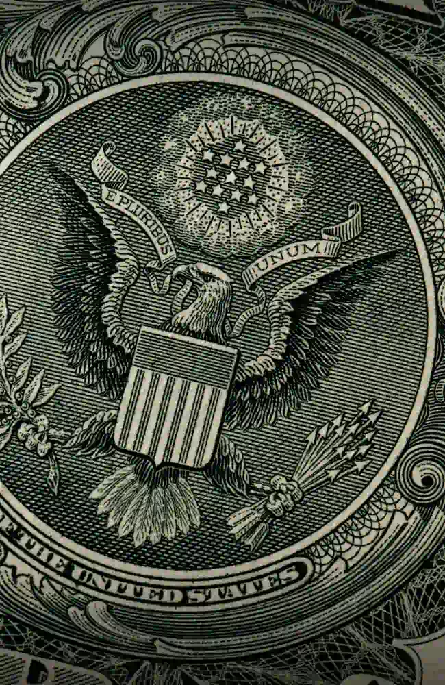 A detail of a banknote depicting the americal eagle holding a banner with the phrase 'E pluribus unum'