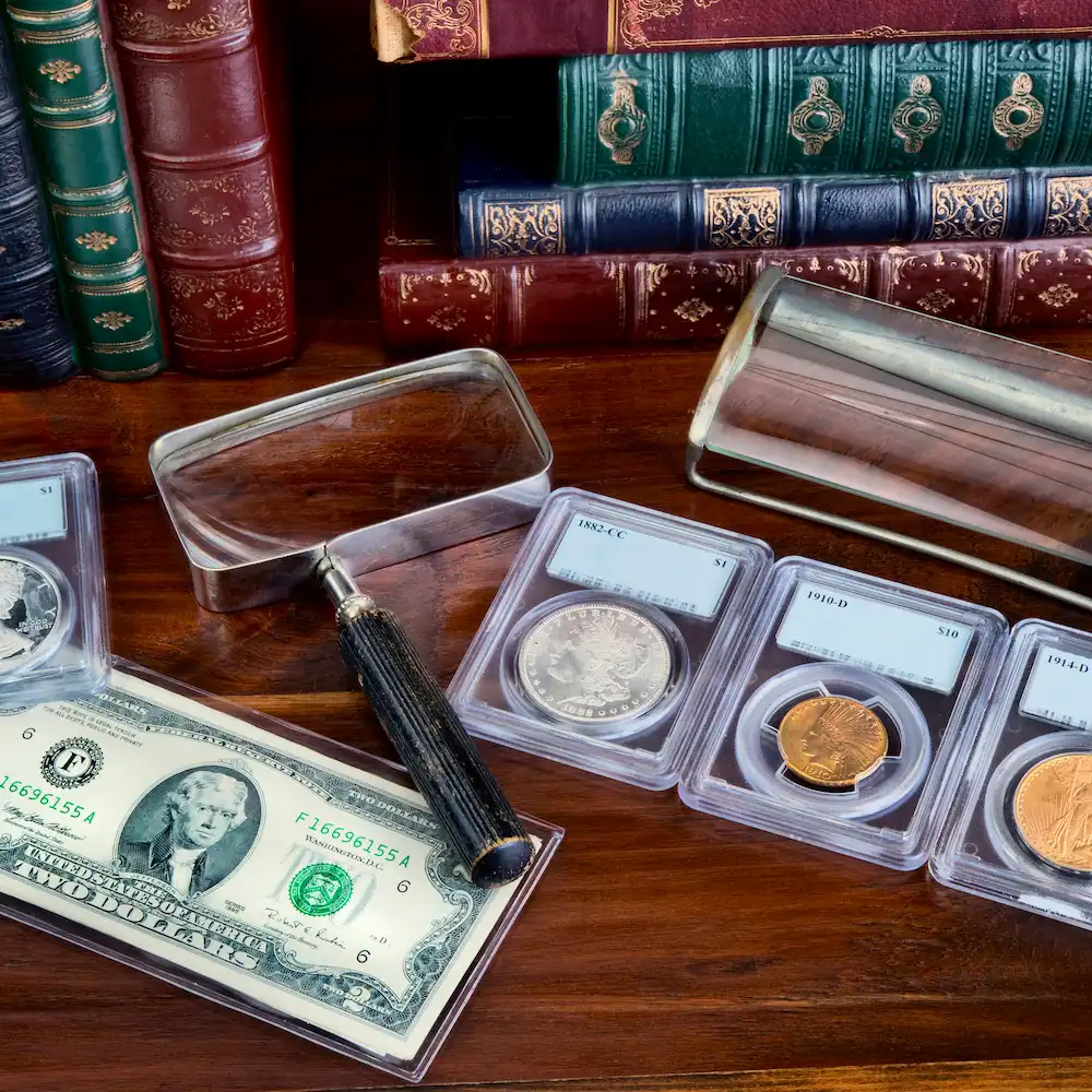 A coin album with silver and gold coins. A leather book's back in the background.
