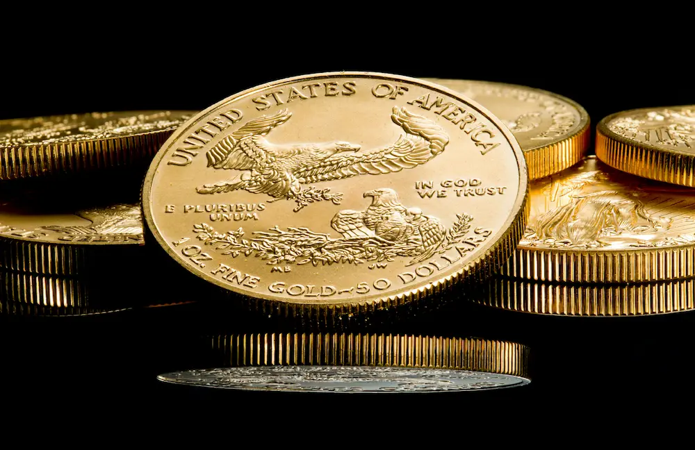 Several United States Gold Coins, 1oz of pure gold, in a dark background. 